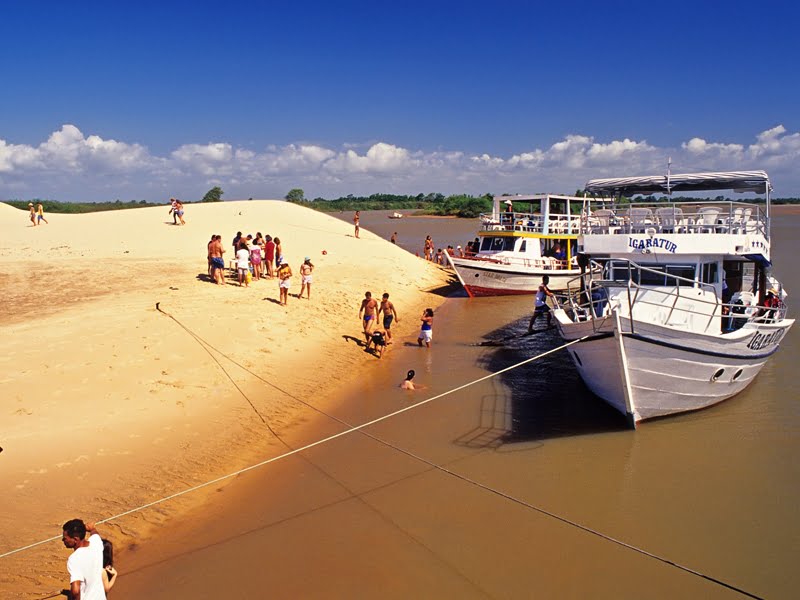 Barco parado em uma praia com turistas descendo